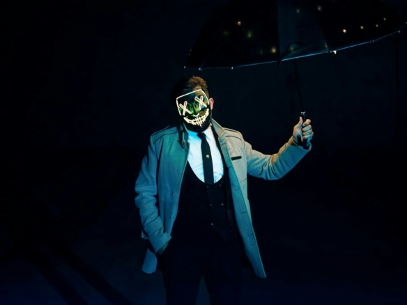 a man in a suit and mask holding an umbrella