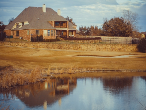 brown and white house near body of water during daytime