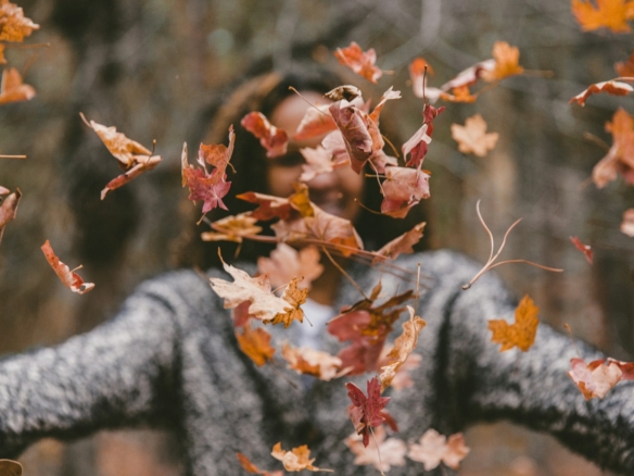 woman throwing maple leaves